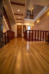 an empty room with wooden floors and a brick wall at The Land Hotel & Apartment in Vung Tau