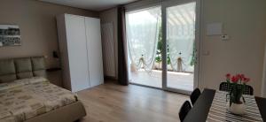 a living room with a bed and a sliding glass door at Le casette in Monopoli
