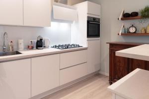 a white kitchen with a sink and a stove at Kustappartementenkatwijk 2F in Katwijk aan Zee