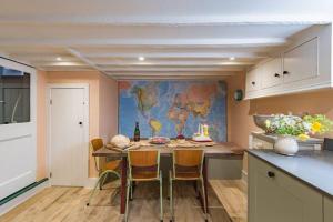 a kitchen with a table with chairs and a map on the wall at Noggin in Deal