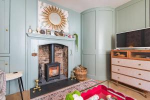 a living room with a fireplace and a tv at Noggin in Deal
