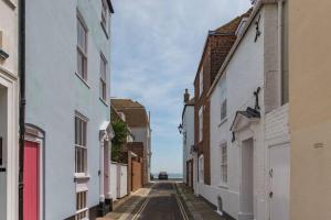 an empty alley with white buildings and the ocean in the background at Noggin in Deal