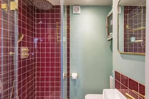 a bathroom with a sink and a shower with purple tiles at Noggin in Deal +39 photos