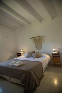 a bedroom with a bed with two towels on it at Las Quimeras in Nono