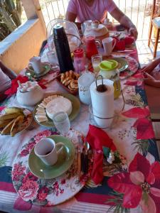 a table with plates of food and cups on it at Pousada Recanto Alegre in Campestre