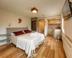a bedroom with a bed and a kitchen at APARTS LA FARFALLA in El Chalten