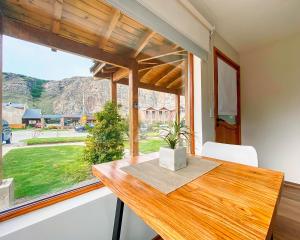 a dining room with a table and a large window at APARTS LA FARFALLA in El Chalten