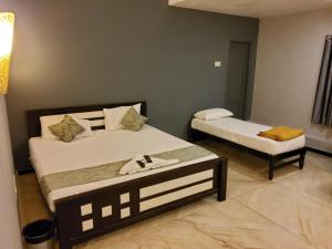 1 dormitorio con 2 camas y mesa. en Le Grace Annasalai, en Chennai