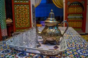 a tea pot on a tray on a table with glasses at Riad Rajy in Fez