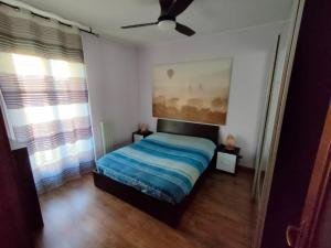 - une chambre avec un lit et un ventilateur de plafond dans l'établissement Appartamento Il Girasole, à Casatenovo