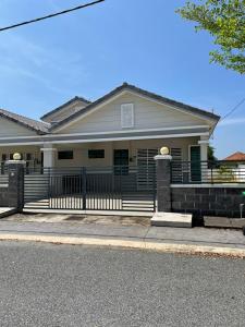 ein Haus mit einem Zaun davor in der Unterkunft Family Holiday Home With Wifi & Netflix in Sungai Petani