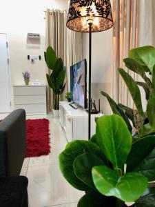 a living room with a lamp and green plants at RumahKu Homestay, Taman Jasin Perdana in Jasin