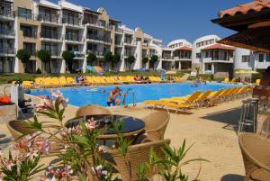 een zwembad in een resort met stoelen en mensen die zwemmen bij DIAMOND Apart Complex in Sveti Vlas