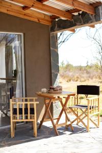 einen Holztisch und Stühle auf einer Terrasse in der Unterkunft Las Quimeras in Nono