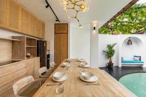 a dining room with a table and a swimming pool at The Lagoon Canggu in Canggu