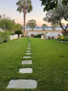 a stepping stone pathway in a grass field at Villa Maria-Stunning Villa in Porto Hydra in Thermisía