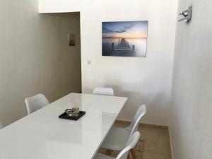 un comedor blanco con una mesa y sillas blancas en Apartamento con piscina - Tossa - Magníficas vistas al mar, en Girona