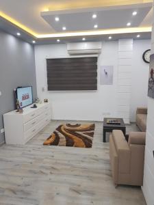 een woonkamer met een bank, een tv en een tafel bij Flat 01 bed room. Sea Street. Hadaba Area. in Sharm El Sheikh