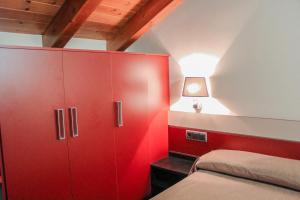 um quarto vermelho com uma cama e um armário vermelho em Hotel Saloria em Alins