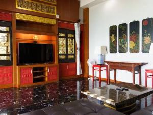 a living room with a television and a table at Patong 4BD sea view BOOM party&cozy pool villa in Ban Nakhale