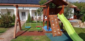 un parque infantil con tobogán y estructura de juegos en Harmónia Parasztház és Apartman, en Poroszló