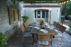 una mesa de madera y sillas en un patio en At Home In Istria- Villa Stancia Cicada en Žminj
