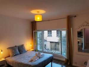 ein Schlafzimmer mit einem Bett und einem großen Fenster in der Unterkunft Studio ruffec 10 in Ruffec