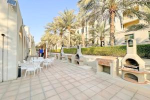 a patio with tables and chairs and a fireplace at Bright Sunny Dubai Apartment- Private Terrace Garden- Canal Views- Pool & Gym in Dubai