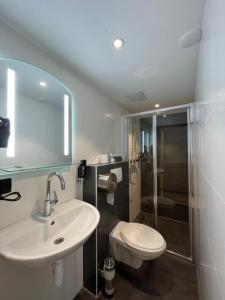 een badkamer met een wastafel, een toilet en een douche bij Heart of Amsterdam Hotel in Amsterdam