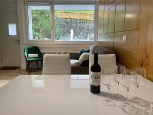 a bottle of wine sitting on a table with wine glasses at Casa Lorica Marilleva 1400 in Marilleva