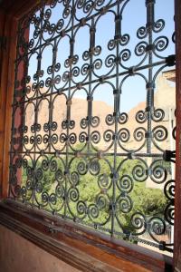 ein Eisenfenster mit Blick auf einen Hof in der Unterkunft La Belle étoile in Aït Oussane