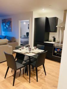 een eetkamer en een woonkamer met een tafel en stoelen bij Manchester lovely two bedrooms apartment in Broadheath