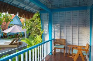 a porch of a house with a table and chairs at The MG Villa & SPA in Nusa Penida
