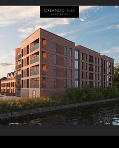 een weergave van een bakstenen gebouw naast een waterlichaam bij Manchester lovely two bedrooms apartment in Broadheath