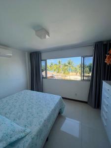 um quarto com uma cama e vista para a praia em Ed Canoa Apartamentos Temporada em Maceió