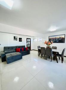 uma sala de estar com um sofá e uma mesa em Ed Canoa Apartamentos Temporada em Maceió