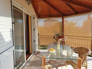 a glass table and chairs on a patio at Apartmani Danja in Kaštela