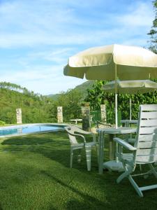 un tavolo e sedie con ombrellone accanto a una piscina di B&B Ca dei Fre a Genova