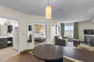 a living room with a table and a bedroom at Candlewood Suites Erie by IHG in Erie