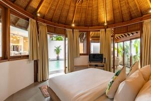 a bedroom in a villa with a bed and a television at The Lagoon Canggu in Canggu