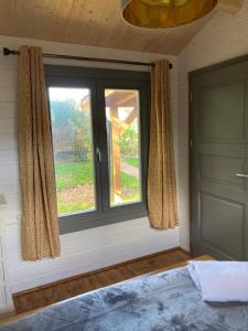 Dormitorio con ventana, cama y puerta en Number 15 Frome, en Frome