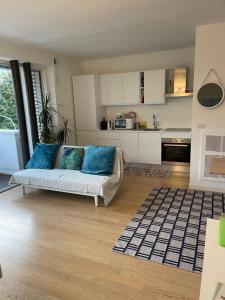 a living room with a couch and a kitchen at Appartamento Ligeia in Bolzano