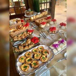 une table garnie de assiettes de nourriture et de pâtisseries dans l'établissement Pousada Blanca Mar, à Búzios