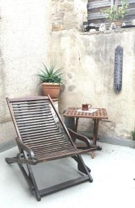 a wooden chair and a table next to a wall at Le logis d'Hestia in Billom