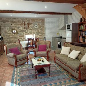 a living room with couches and chairs and a table at Casa da Eira in Lobios