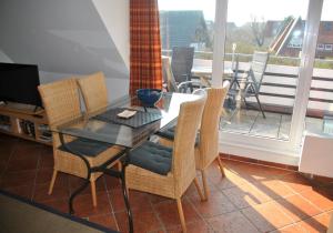 a dining room with a table and chairs and a balcony at Strandlooper Strandlooper Dünenkoje05 in Norderney