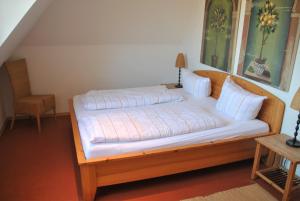 a bedroom with a large bed with white sheets at Strandlooper Strandlooper Dünenkoje05 in Norderney