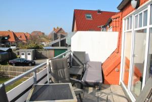 a balcony with two chairs and a table at Strandlooper Strandlooper Dünenkoje05 in Norderney
