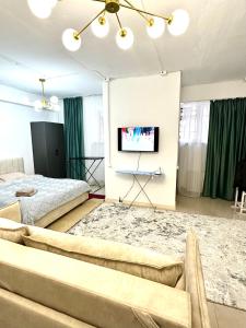 a bedroom with a bed and a flat screen tv at Evita Apartment in Bishkek