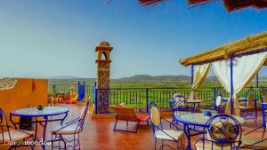 a patio with tables and chairs and a clock tower at Dar Amoudou in Ouarzazate
